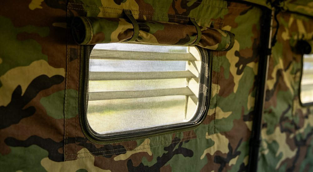 Close-up of military tent ventilation window with mesh screen, camouflage fabric frame, detailed design feature, professional product photography professional high quality realistic photography with detailed composition and natural lighting conditions