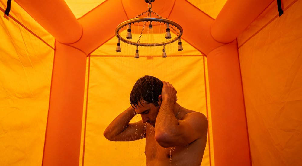 Circular shower ring inside inflatable decon tent, simple circular shower head, bright interior red and white inflatable emergency shelter for disaster relief operations