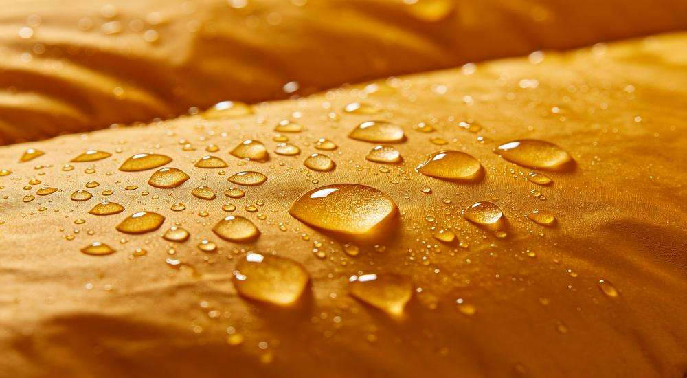 Close up of water droplets rolling off sleeping bag outer fabric, waterproof DWR coating test, macro product photography Close up of water droplets rolling off sleeping bag outer fabric, waterproof DWR coating test, macro product photography