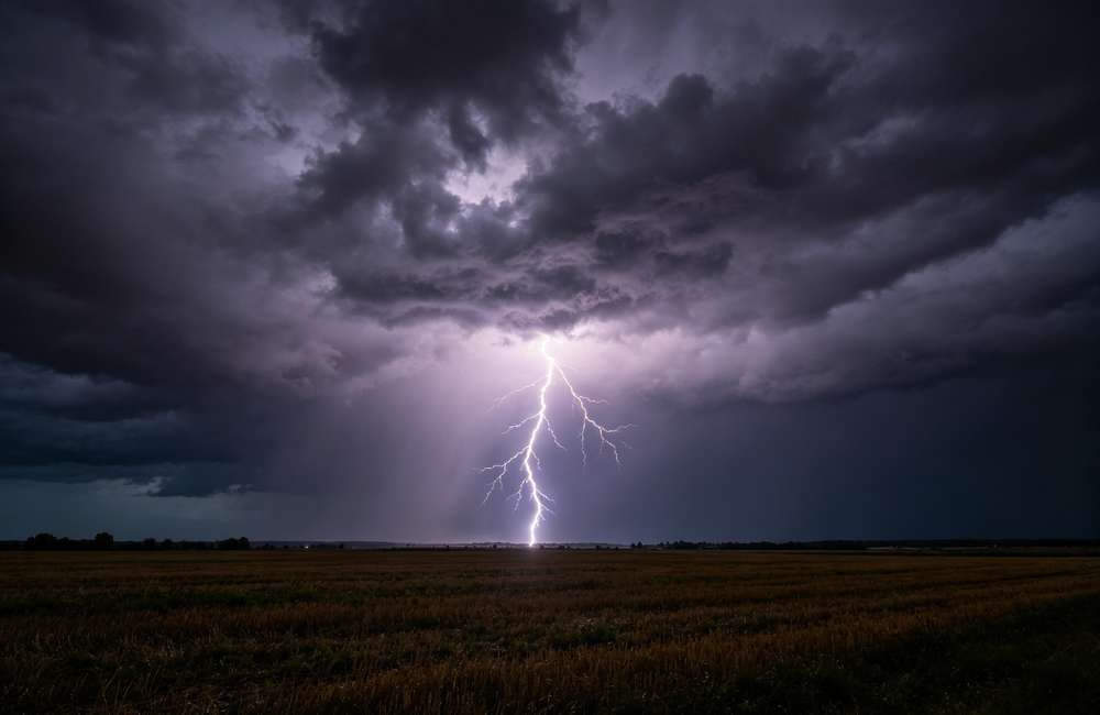 Dramatic lightning bolt striking across dark sky during severe thunderstorm, showing why bulk storm safety supplies are essential for outdoor events and shelters.