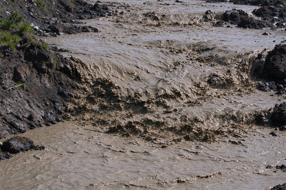 Lahar mudflow flowing through volcano terrain, volcanic hazard awareness and volcano emergency kit preparation for evacuation Lahar mudflow flowing through volcano terrain, volcanic hazard awareness and volcano emergency kit preparation for evacuation